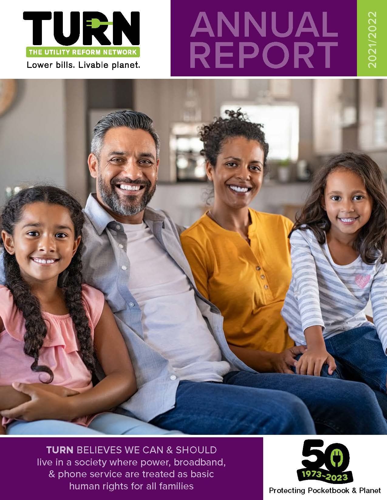 Family of four sitting on a couch, smiling in a cozy home setting.